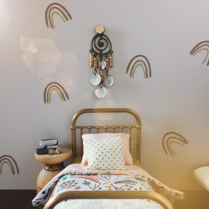 A close up of miniature rainbow wall decals in a doll's house.