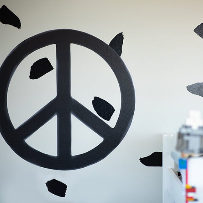 Monochrome peace symbol removable wall decal in a boy's bedroom.